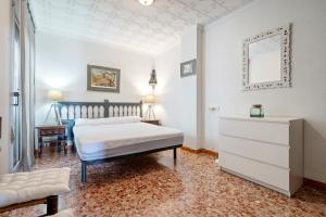 a bedroom with a bed and a dresser and a mirror at Ático Cesar Cataldo in Benicarló