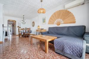 a living room with a blue couch and a table at Ático Cesar Cataldo in Benicarló