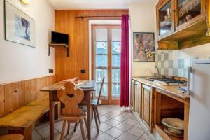 a kitchen with a wooden table and a dining room at Appartamento Moti in Caldes