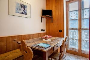 a dining room with a wooden table and chairs at Appartamento Moti in Caldes