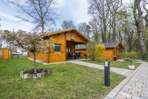 a log cabin with a tree in the yard at Ferienhaus 4 Familie Täubert in Klein Uhyst