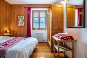 a bedroom with a bed and a table and a window at Appartamento Moti in Caldes