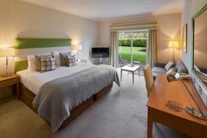 a bedroom with a large bed and a television at Donnington Hotel, Spa & Golf in Newbury