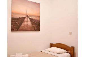 a bedroom with a painting of a lighthouse on the wall at Manolika Studio 3 in Kithnos