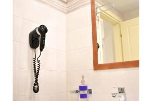a black phone hanging on a wall in a bathroom at Manolika Studio 3 in Kithnos +2 photos