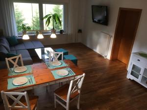 a kitchen and living room with a wooden table and chairs at Ferienwohnung Am Sieperloh in Stryck
