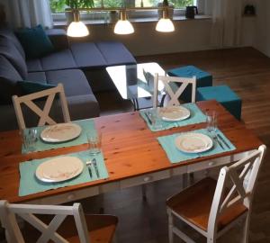 a wooden table with four chairs and plates on it at Ferienwohnung Am Sieperloh in Stryck +11 photos