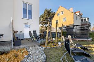 a backyard with chairs and a table and a house at Ferienwohnung Andreas in Naumburg