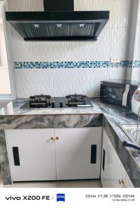 a kitchen with a stove and a counter top at Aroyapoolvilla69 in Ban Yep Chaeng