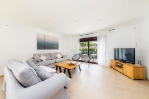 a living room with a couch and a tv at Villa Casa Bon Sol in Capdepera