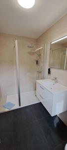 a white bathroom with a sink and a shower at Hotel-Pension Zur Mole in Wiek auf Rügen +24 photos