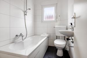 a bathroom with a tub and a toilet and a sink at Haus am Garten in Brunkensen
