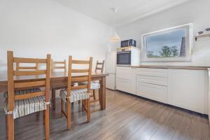 a kitchen with a table and chairs and a tv at Haus am Garten in Brunkensen