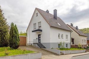 a white house with a black roof at Haus am Garten in Brunkensen