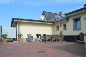 a patio with chairs and a table in front of a house at Müritz - Domizil in Waren
