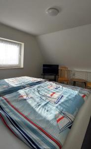 a bedroom with a bed with a colorful blanket on it at Müritz - Domizil in Waren