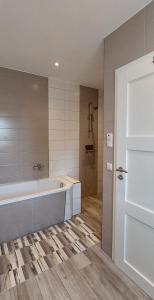 a white bathroom with a tub and a shower at Müritz - Domizil in Waren +17 photos