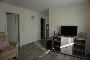 a living room with a flat screen tv on a entertainment center at Müritz - Domizil in Waren