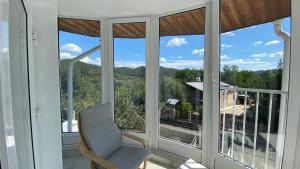 a chair on a balcony with a view of the mountains at Casa NICORAD Apartamente in Pucioasa