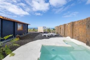 a backyard with a swimming pool and a house at Villa Dely in Tazacorte