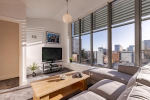 a living room with a couch and a tv at Penthouse Split Level 5 min walk to City Centre in Coventry