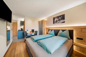 a bedroom with a large bed with blue pillows at Oberhaushof in Santa Valpurga