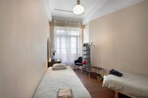 a bedroom with two beds and a desk and a window at A Casa Formosa in Porto