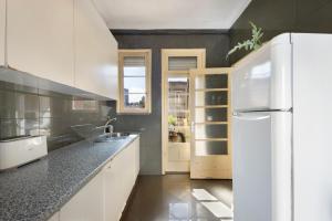 a kitchen with white cabinets and a white refrigerator at A Casa Formosa in Porto
