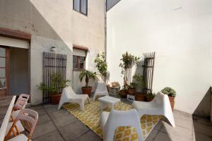 a patio with white chairs and tables and potted plants at A Casa Formosa in Porto
