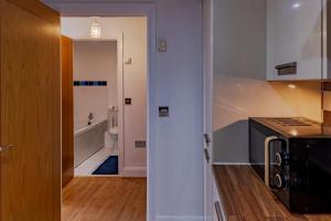 a kitchen with a sink and a microwave at Penthouse Split Level 5 min walk to City Centre in Coventry +52 photos