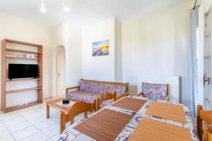 ein Zimmer mit einem Bett, einer Couch und einem Tisch in der Unterkunft Olivea Apt 4 in Acharavi