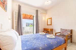 ein Schlafzimmer mit einem Bett, einem Stuhl und einem Fenster in der Unterkunft Olivea Apt 4 in Acharavi