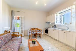 eine Küche und ein Wohnzimmer mit Sofa und Tisch in der Unterkunft Olivea Apt 4 in Acharavi