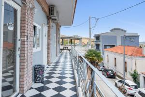 a balcony with a black and white checkered floor at Motel katerina in Keratea +16 photos