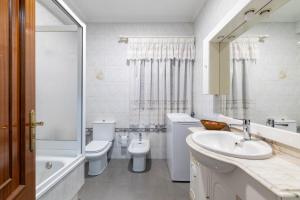 a bathroom with a sink and a toilet and a tub at Piso Calle Sarria in Monforte de Lemos