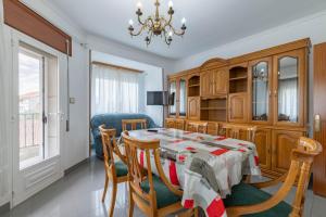 a dining room with a table and chairs and a chandelier at Piso Calle Sarria in Monforte de Lemos +16 photos