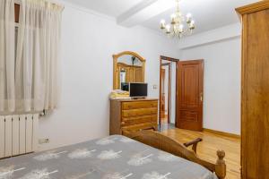 a bedroom with a bed and a dresser with a mirror at Piso Calle Sarria in Monforte de Lemos
