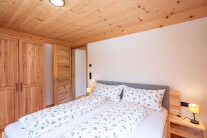 a bedroom with a white bed and a wooden ceiling at Haus Hoalp in Au