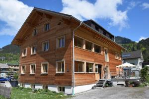 a large wooden building with a porch at Haus Hoalp in Au