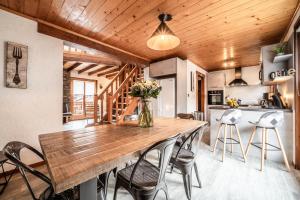a kitchen and dining room with a wooden table and chairs at Appartement chalet - Le Caribou in Morzine
