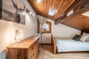 a bedroom with a bed and a desk with a lamp at Appartement chalet - Le Caribou in Morzine