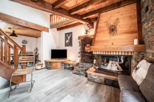 a living room with a fireplace and a television at Appartement chalet - Le Caribou in Morzine