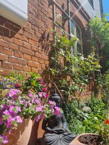 a statue in front of a brick building with flowers at Ferienwohnung Pieck in Raduhn