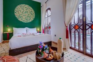 a bedroom with a bed and a green wall at Riad Lalla Azalay in Marrakesh