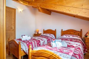 two twin beds in a bedroom with wooden ceilings at Cuore delle Dolomiti in Tonadico