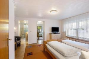 a bedroom with two beds and a living room at Ferienwohnung Alwine Schulte in Brilon