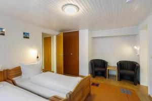 a bedroom with a bed and two chairs and a table at Ferienwohnung Alwine Schulte in Brilon