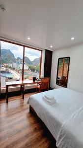 a bedroom with a large bed and a large window at Viet Son Lam Hotel in Dồng Văn