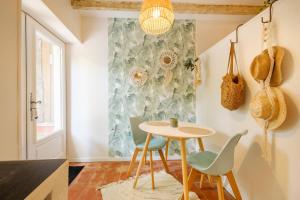 a small table and chairs in a room with a window at Le Jardin des Oiseaux in Clans