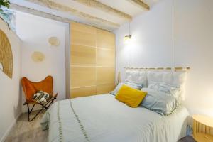 a bedroom with a bed with yellow and blue pillows at Le Jardin des Oiseaux in Clans